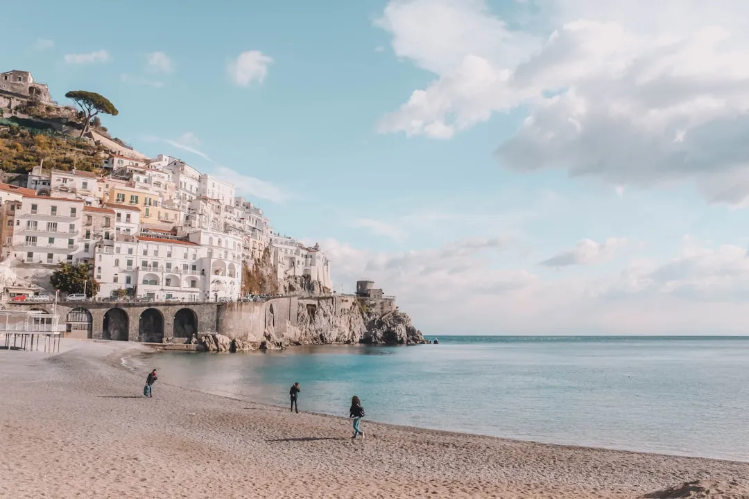 View of Amalfi Coast beach with white buildings cascading down the cliffside
