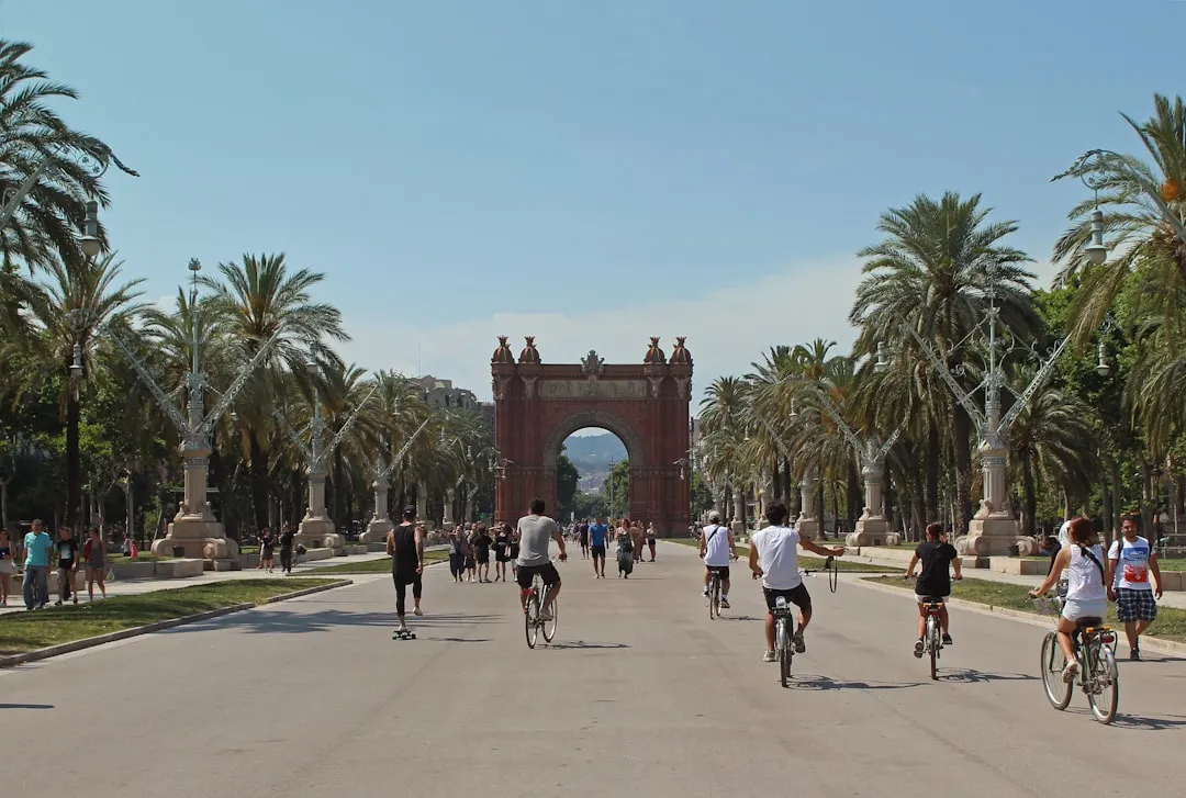 Barcelona's Arc de Triomf with palm-lined promenade and cyclists