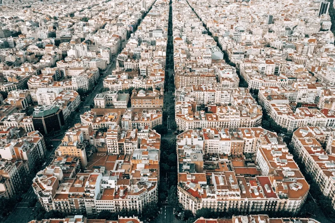 Aerial view of Barcelona's Eixample district showing symmetrical grid pattern with two main intersecting avenues