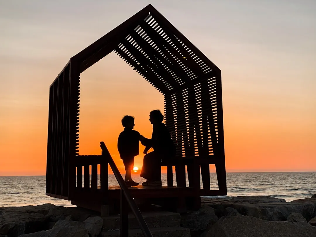 A mother and a child spending some quality time together in a hut on a Portuguese beach at sunset