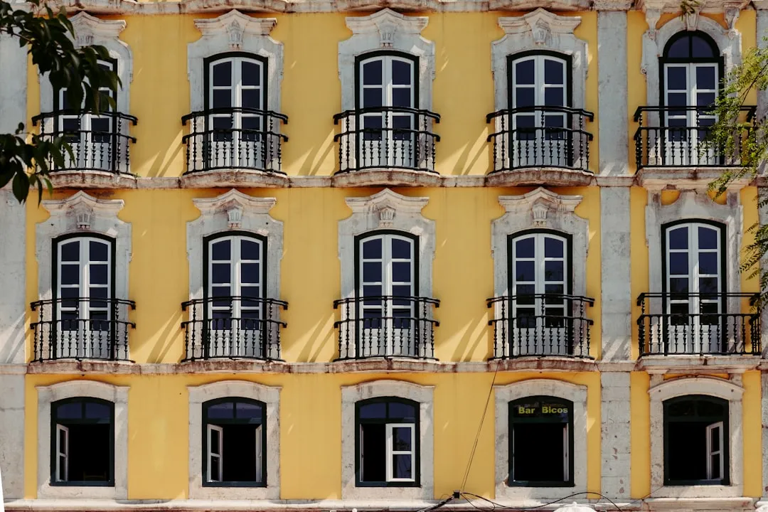 Yellow building facade with repetitive pattern of balconies